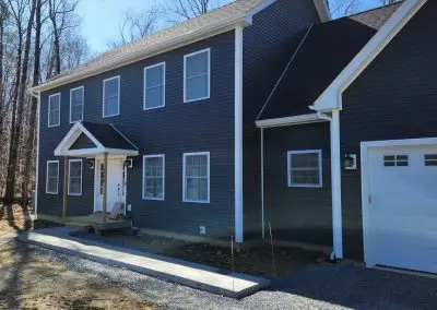 Navy blue colonial in Addison County VT with white seamless gutters and downspouts